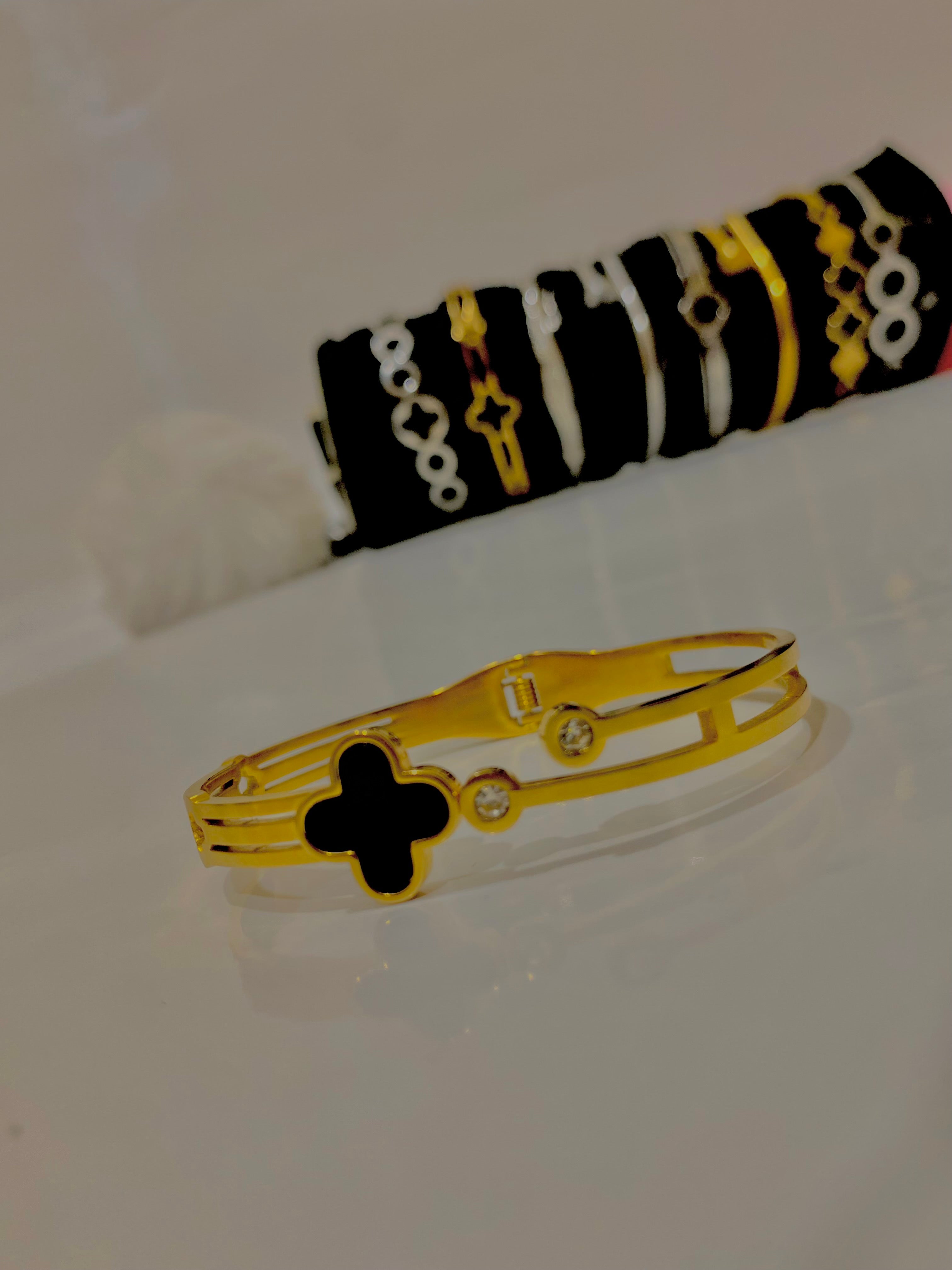 Elegant Gold Bracelet with Diamonds and Black Clover Design