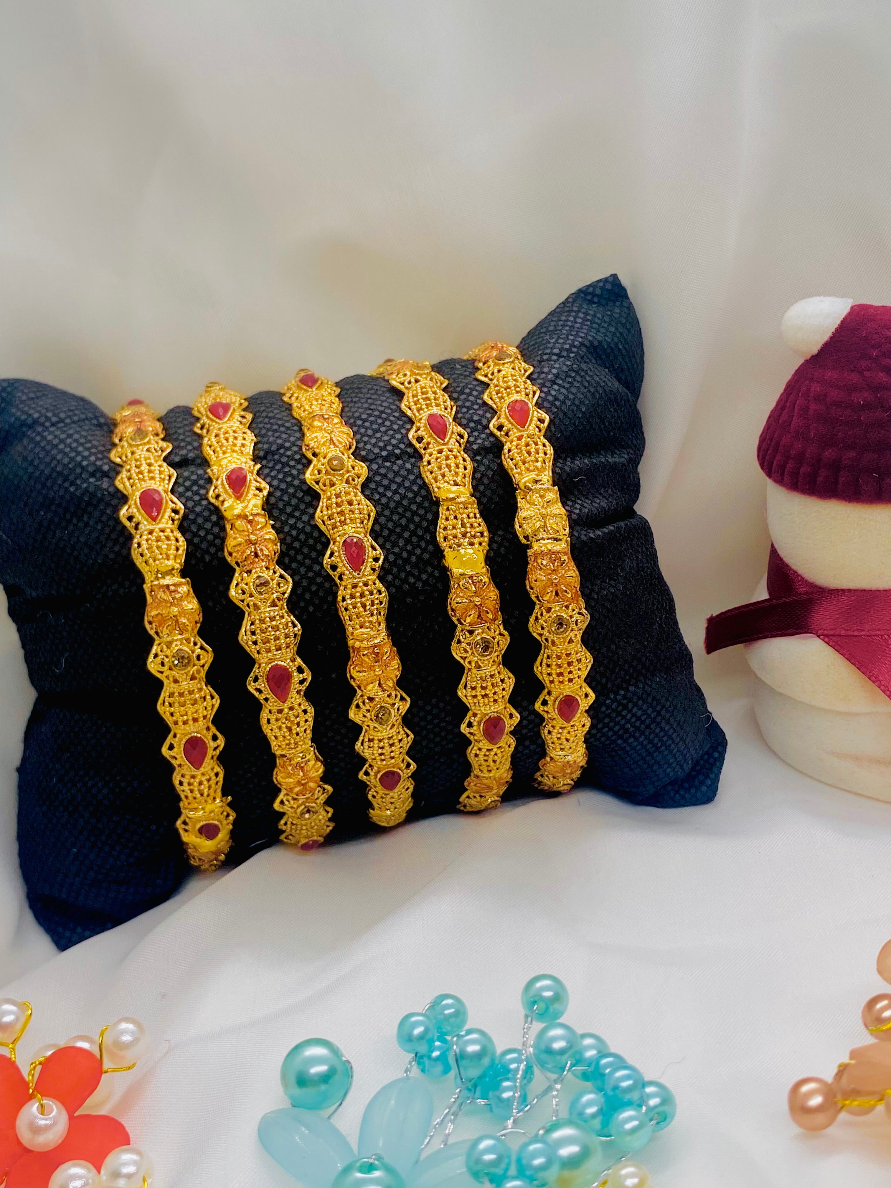Set of Four Elegant Traditional Gold Bangles with Ruby Red Stones
